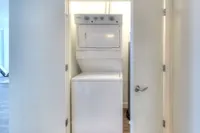 Modern apartment laundry space featuring a sleek, compact stackable washer and dryer unit, efficiently designed for convenience.