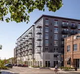 Modern urban apartment complex with stylish balconies and vibrant street view.