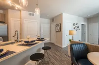 Contemporary open-plan apartment with elegant lighting, sleek kitchen island, and stylish dining area boasting modern decor.