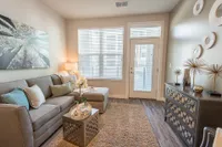 Inviting living room with stylish decor, large windows, and plush seating arrangement, perfect for relaxation and entertaining.