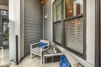 Charming outdoor patio with modern seating, elegant blue cushions, and stylish decor, perfect for relaxation.