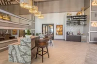 Chic apartment interior showcasing elegant lighting, modern decor, and a stylish counter with seating, creating a welcoming atmosphere.
