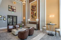 Inviting lounge with modern decor, featuring stylish leather chairs, contemporary art pieces, and elegant lighting for a luxurious ambiance.