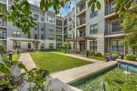 Charming apartment complex with modern architecture, lush courtyard, and tranquil water features.