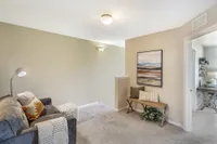 Chic apartment interior featuring a cozy alcove with a plush gray sofa, modern artwork, and soft lighting.