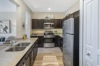 Modern kitchen with sleek stainless steel appliances, elegant dark cabinetry, and a stylish open-plan design.