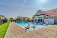 Inviting outdoor pool area with modern lounge chairs and sunny residential backdrop, perfect for relaxation and leisure.