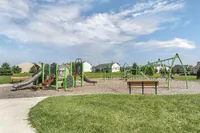 Inviting community playground featuring modern green and brown play equipment, set against a backdrop of a beautifully maintained neighborhood, perfect for family fun.