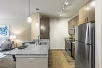 Modern kitchen with sleek stainless steel appliances, beautiful granite countertops, and cozy seating area, ideal for entertaining.