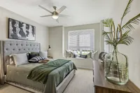 Elegant bedroom with a plush bed, stylish decor, and a cozy window seating area, offering a tranquil retreat filled with natural light.