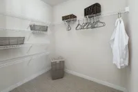 Spacious walk-in closet with multiple wire shelves, elegant hangers, and storage baskets, perfect for organized and stylish living.