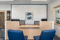 Modern and inviting apartment lobby featuring stylish seating and chic wall design under soft lighting.