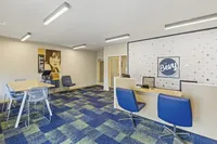 Modern leasing office at The Bevy with vibrant blue accents, stylish seating, and a chic wall design.