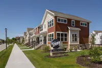 Charming exterior view of The Betty Apartments showcasing modern townhouses with inviting entryways and well-maintained landscaping on a sunny day.