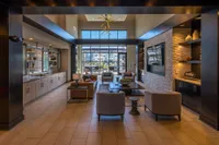 Luxurious modern lobby featuring elegant furniture, stylish decor, and large windows with a view of outdoor seating.