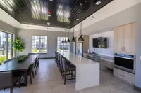 Spacious modern kitchen with elegant white island, stylish pendant lighting, and adjacent dining area perfect for entertaining.