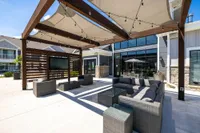 Chic outdoor seating area with stylish sofa sets and modern pergola, perfect for cozy gatherings.