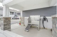 Chic outdoor area featuring a modern pet washing station with stylish brick pillars and ample driveway space.