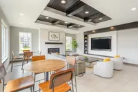 Inviting modern living space with chic wooden accents, cozy seating, and a stylish fireplace, perfect for relaxation and entertainment.