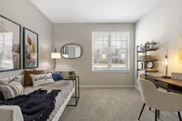 Bright and inviting home office with a cozy daybed, elegant decor, and a spacious desk, ideal for a productive and serene workspace.