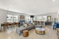Modern and inviting common area with stylish seating, large windows, and a well-equipped kitchen space, perfect for social gatherings.