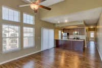 Bright, modern open-plan apartment with elegant wooden floors, stylish kitchen, and large windows offering natural light.