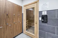 Luxurious apartment amenity featuring a chic wooden sauna and modern locker room for relaxation and convenience.