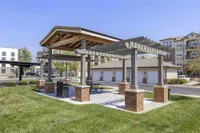 Charming outdoor pavilion with a modern pergola and picnic table, ideal for gatherings, located in a scenic apartment community.