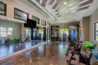 Modern fitness studio with state-of-the-art exercise bikes, full-length mirrors, and vibrant workout balls in a bright, spacious environment.