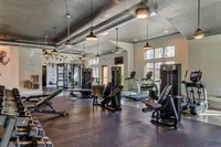 Modern gym facility with a variety of workout equipment including treadmills, weight machines, and free weights, set in a spacious, well-lit environment.