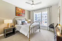 Bright, elegant bedroom with a modern metal bed frame, large window, and stylish decor creating a cozy ambiance.
