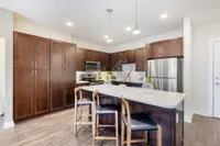 Modern kitchen with sleek cabinetry, stainless steel appliances, and a stylish breakfast bar with pendant lighting.