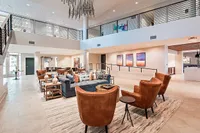 Elegant and inviting open-concept lobby featuring modern leather seating, chic decor, and large artwork on the walls.
