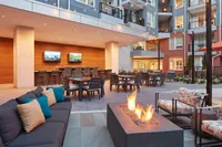 Chic outdoor patio with modern fire pit and stylish seating in a luxurious apartment complex.