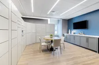 Contemporary and stylish lounge area with a round table, elegant seating, and sleek storage solutions.