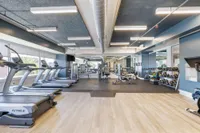 Modern fitness center with state-of-the-art equipment, including treadmills, weight racks, and exercise machines, set in a spacious and well-lit environment.