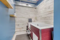 Charming bathroom featuring a modern walk-in bath with rustic wood paneling and soothing blue walls.