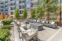Chic outdoor living space with modern seating, lush greenery, and vibrant orange umbrellas, perfect for relaxation and social gatherings.