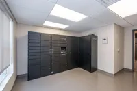 Modern package locker room with sleek black lockers and bright lighting, offering secure parcel storage.
