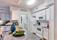 Modern kitchen featuring sleek white cabinetry, elegant countertops, and built-in appliances with a bright, inviting atmosphere.