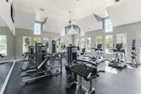 Bright, modern gym with state-of-the-art exercise equipment, large windows, and sleek design for an invigorating workout experience.