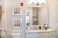 Elegant bathroom with modern granite countertop, framed art, and gleaming mirror offering a bright, inviting space.