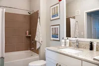 Elegant bathroom with modern granite countertop, chic framed art, and inviting bathtub.