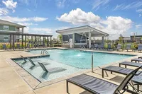 Inviting outdoor pool area with sun loungers and covered seating, perfect for relaxation and leisure in a sunny setting.