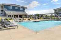 Inviting outdoor pool area with modern lounge chairs and charming pergola, perfect for relaxation and recreation.