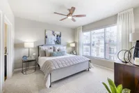 Bright and airy bedroom featuring a plush bed, modern decor, and large window offering ample natural light.