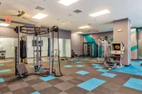 Modern fitness center with state-of-the-art gym equipment, vibrant decor, and spacious workout areas.