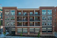 Modern brick apartment building with large windows and private balconies, perfect for urban living.