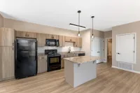 Modern kitchen with elegant granite countertops, sleek black appliances, and stylish wood cabinetry, perfect for gourmet cooking experiences.