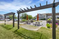 Inviting outdoor area with comfortable hammocks, picnic tables, and vibrant landscaping, perfect for relaxation and social gatherings.
